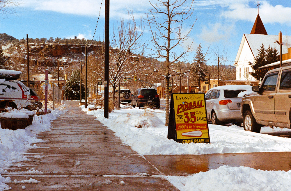 A snowy Colorado town with a sign for a pinball gallery.